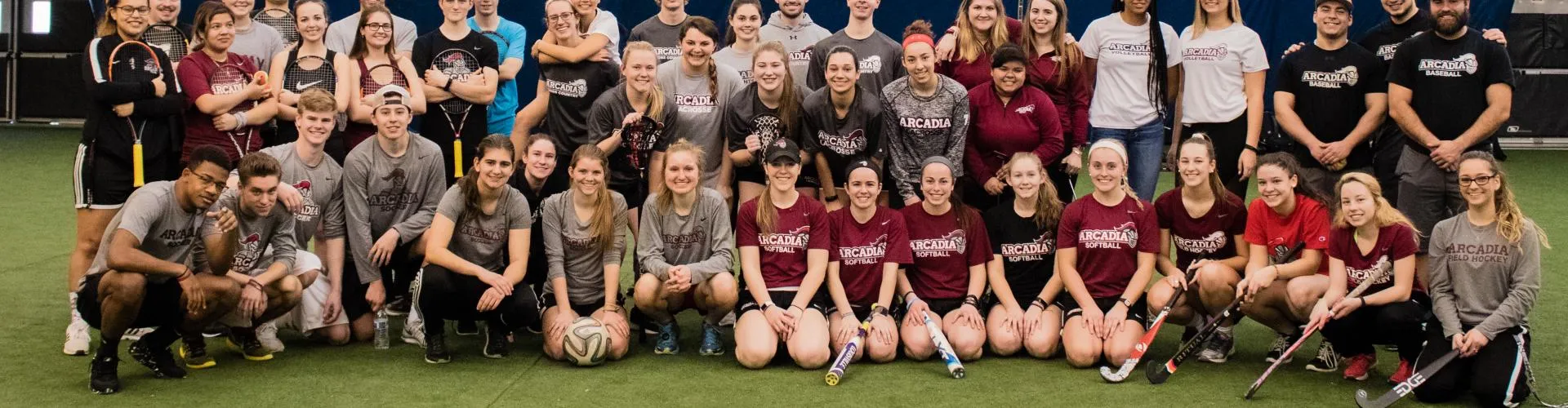 Team members of different Arcadia sports together on a field