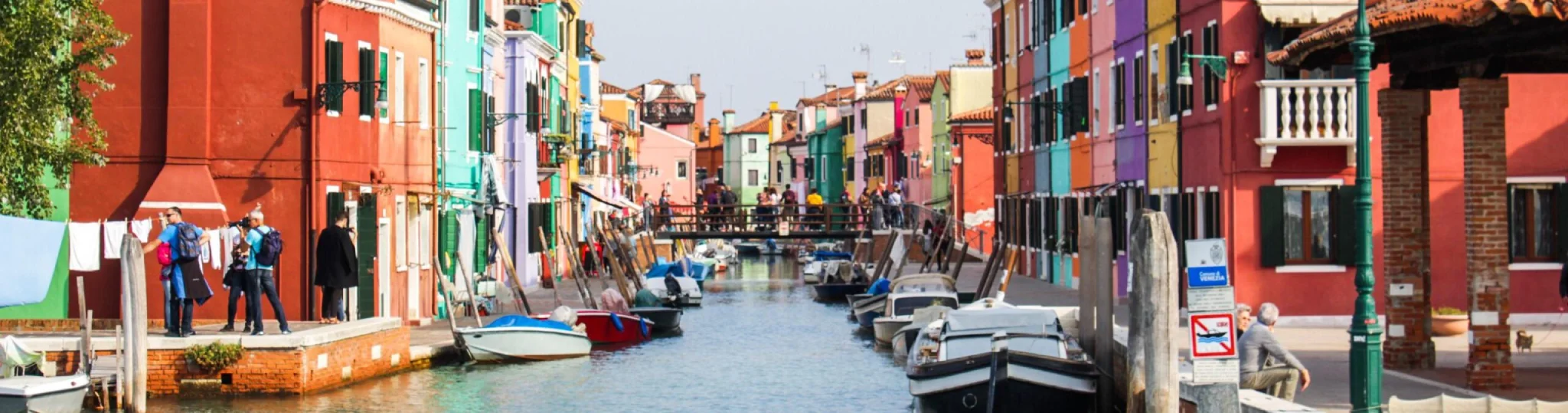 Colorful Italian city with boats for rides lined up on the rise of the river.