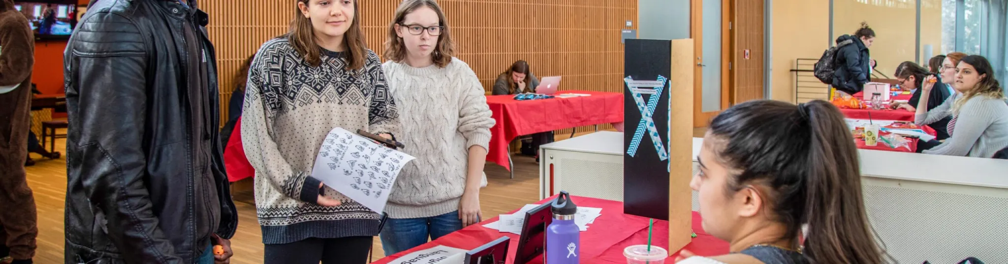 Three people at a table for an activities fair
