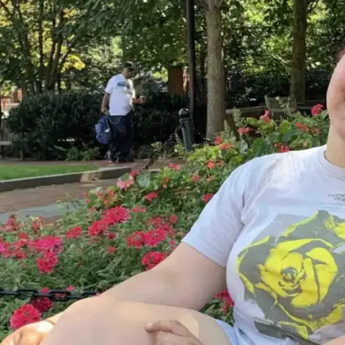 A student lounges near a garden