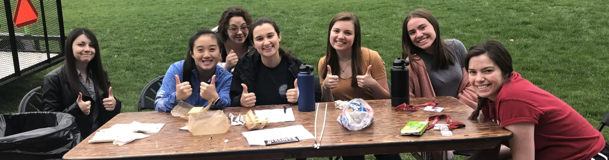 A group of women sitting together giving thumbs up