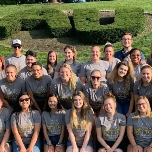 A giant group sitting in front of the "AU" bush on Haber Green