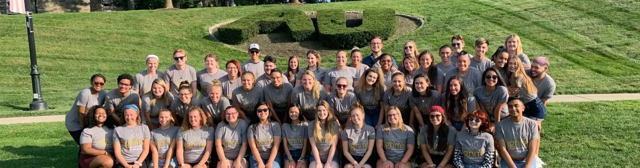 A giant group sitting in front of the "AU" bush on Haber Green