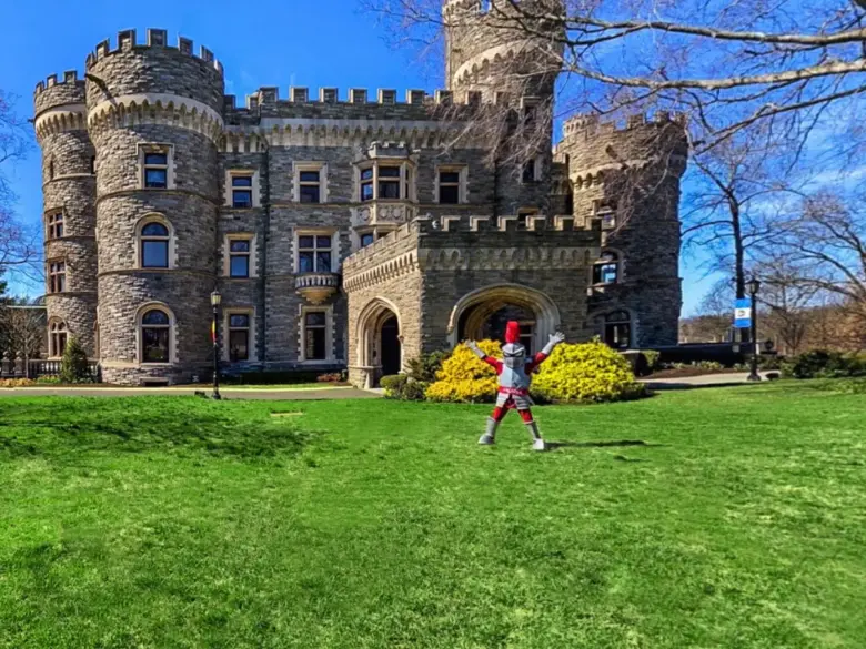 the Arcadia knight mascot in front of the castle