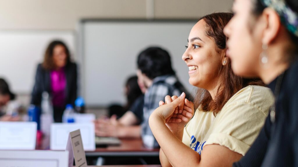 A student smiles while participating in classroom discussion.