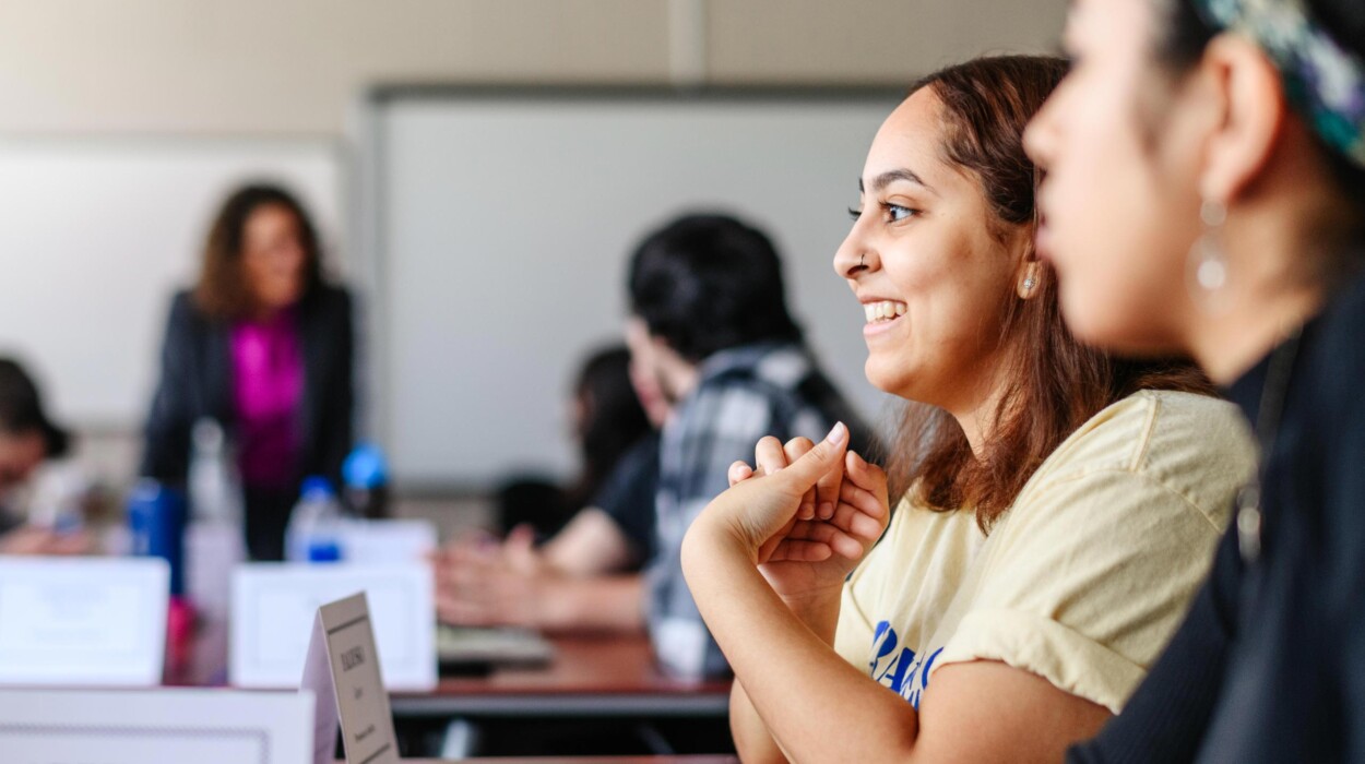 A student smiles while participating in classroom discussion.