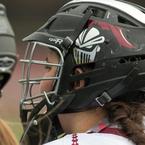 Closeup of women's lacrosse players in helmets