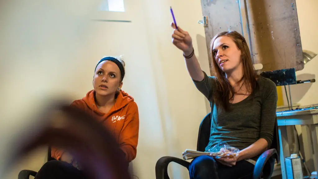 Students point at artwork in a studio.