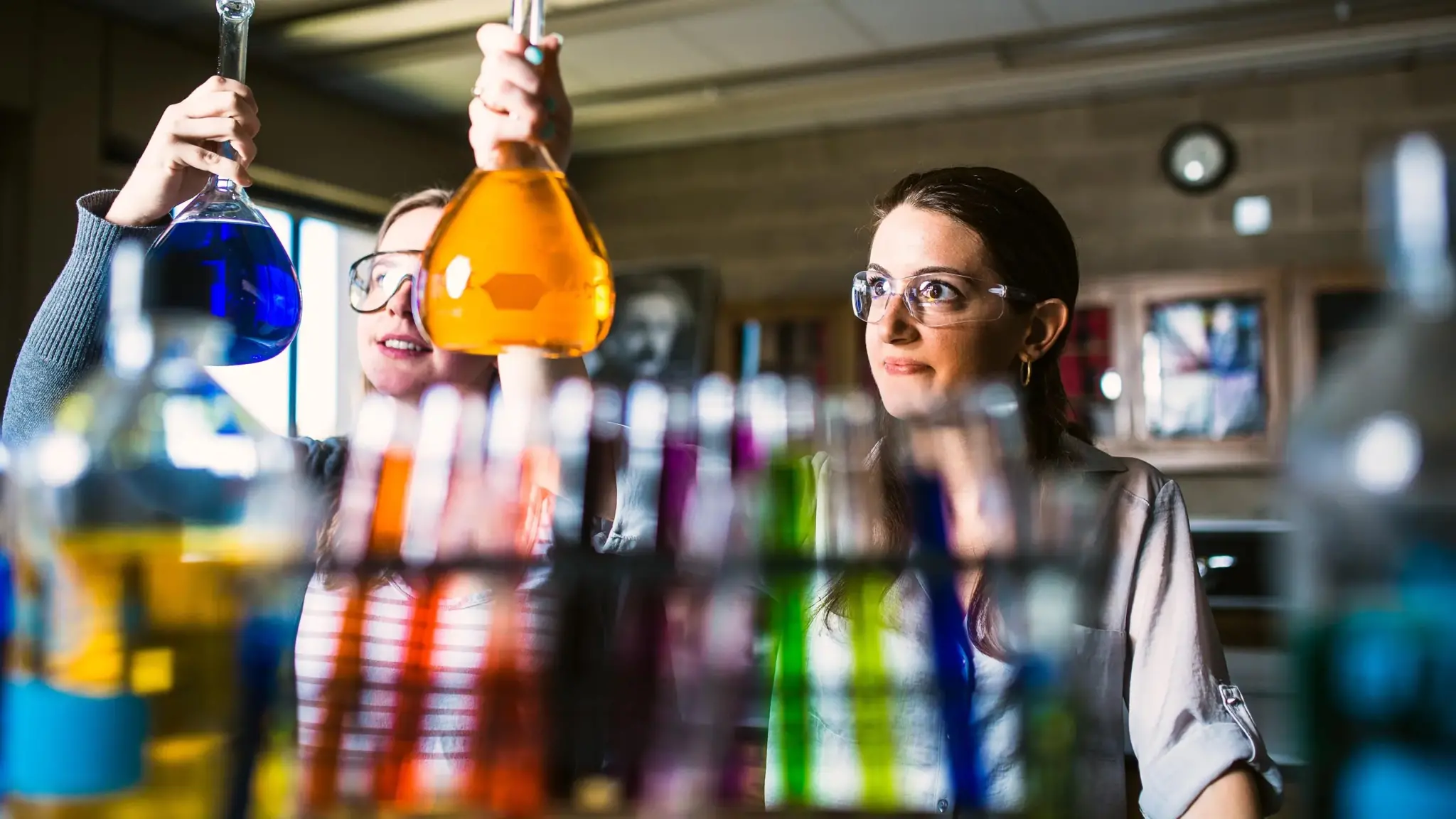 Chemistry students pour liquids in beakers.