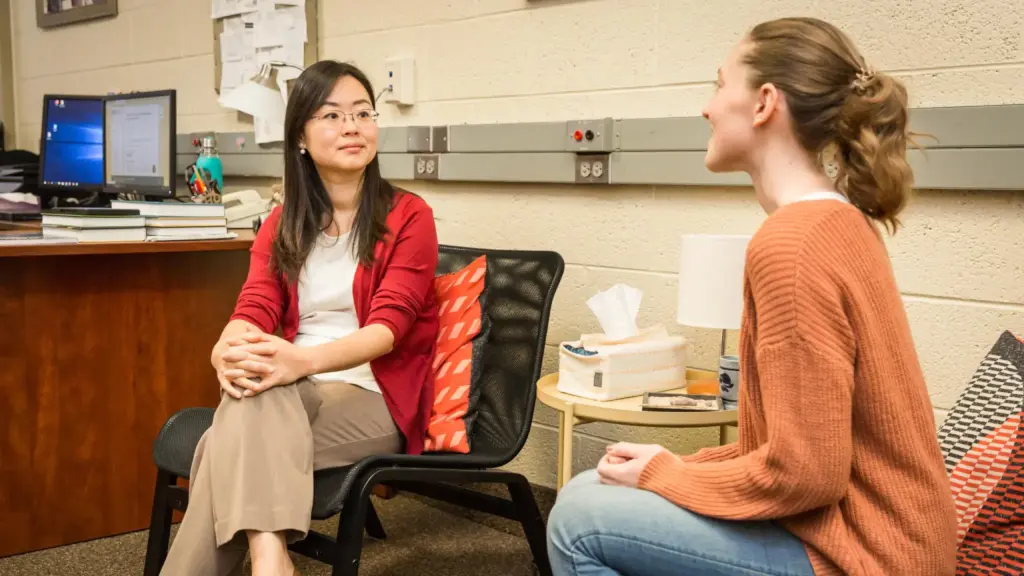 Dr. Cathy Lee talks with a counseling student.