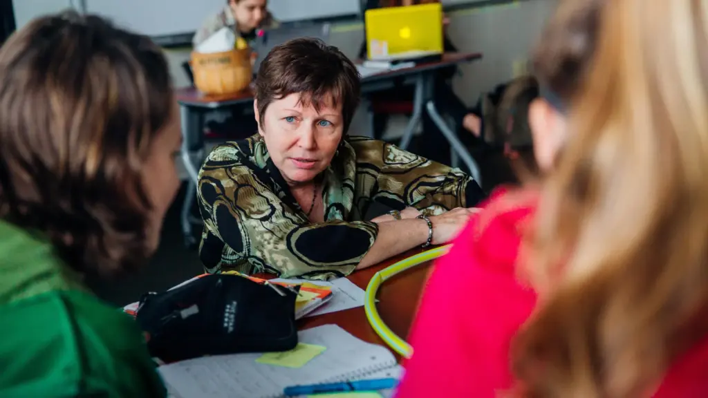 A professor listens to two students.