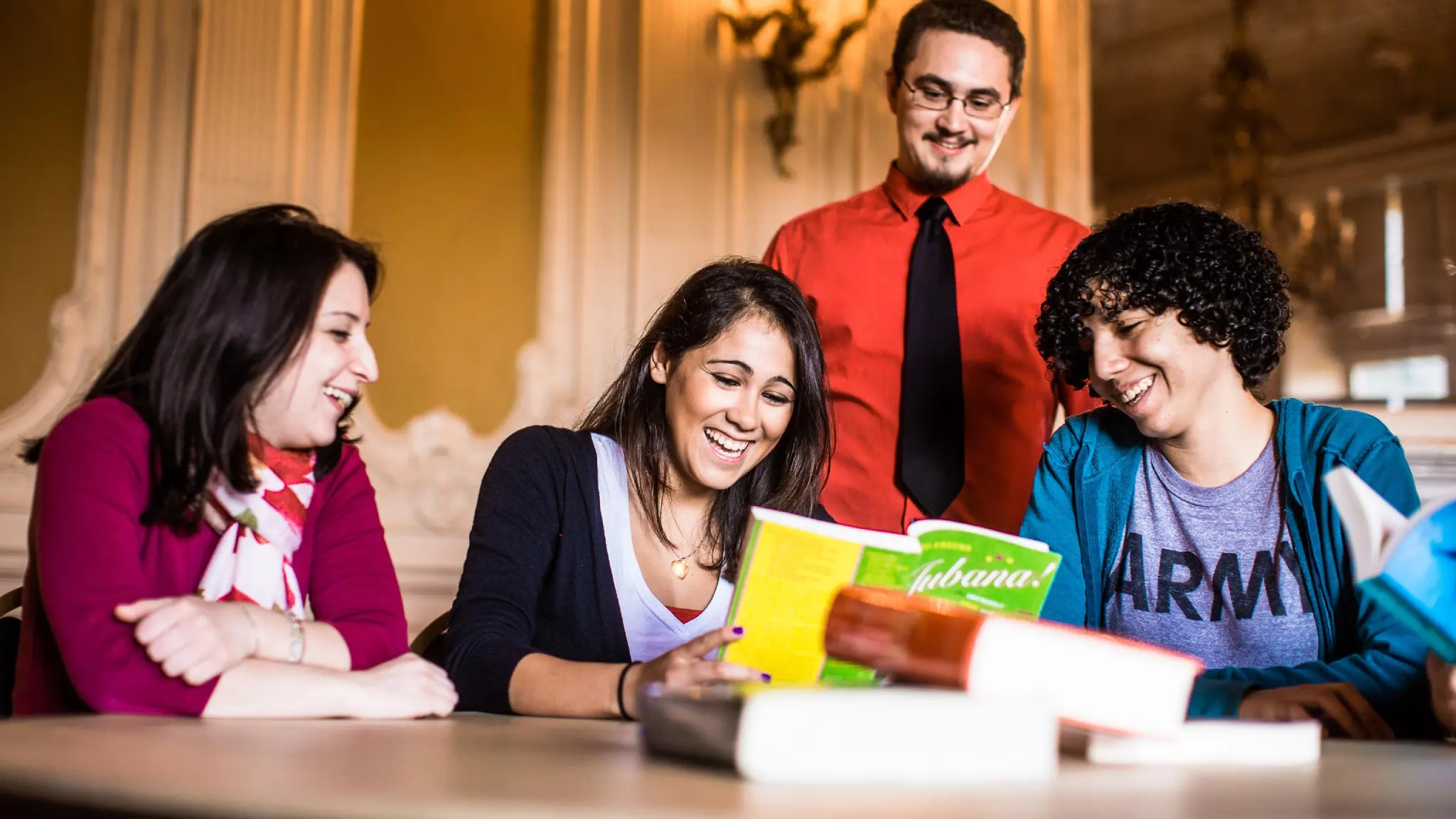 English students laugh while reading a book.