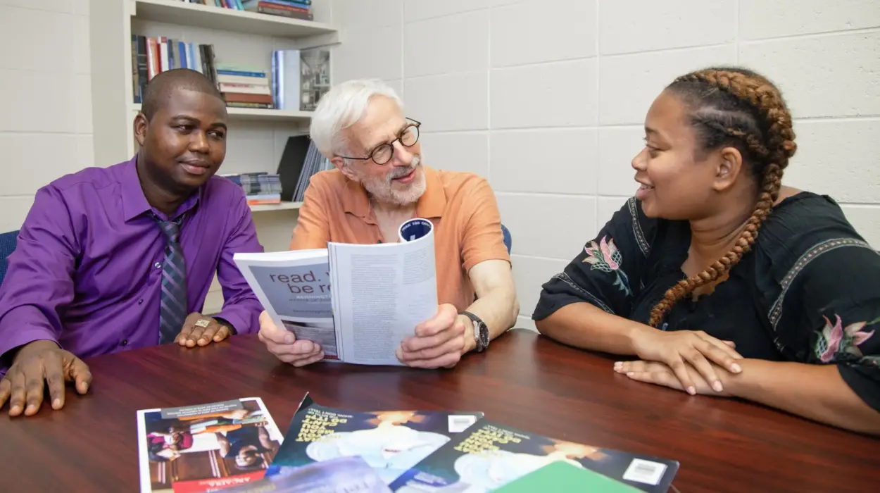 An English professor discusses an article with two students.