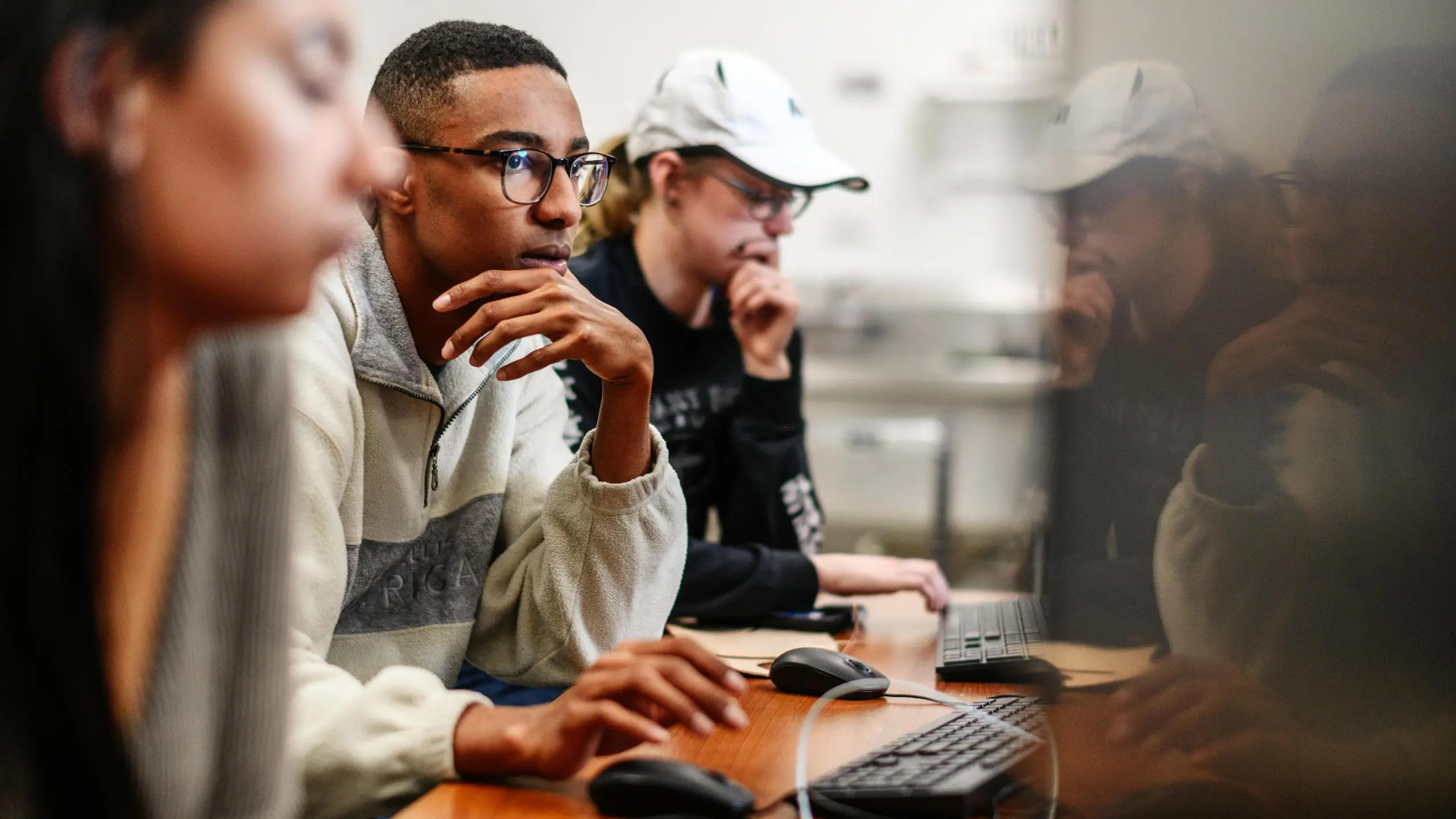 Students use computers in a classroom.