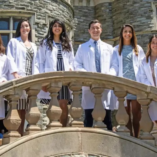 Medical students in white coats outside of Greys Tower.