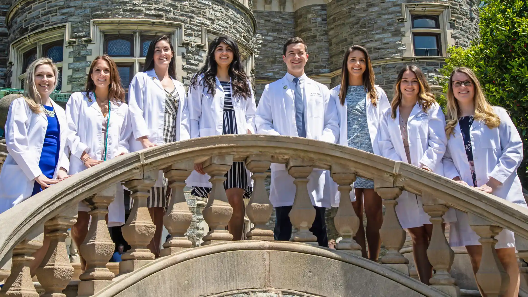 Medical students in white coats outside of Greys Tower.