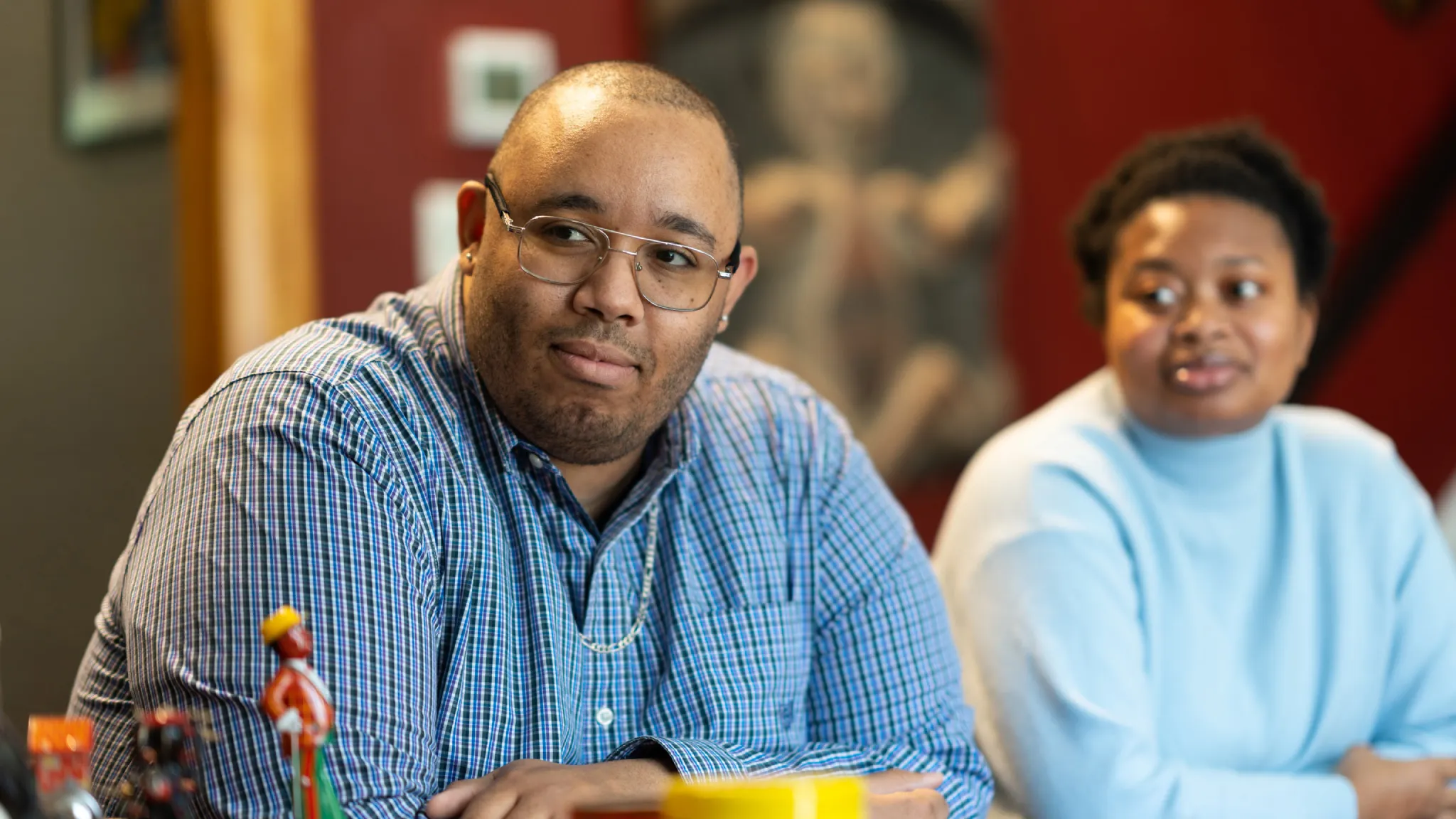 Christopher Allen Varlack and a student listen to a conversation.