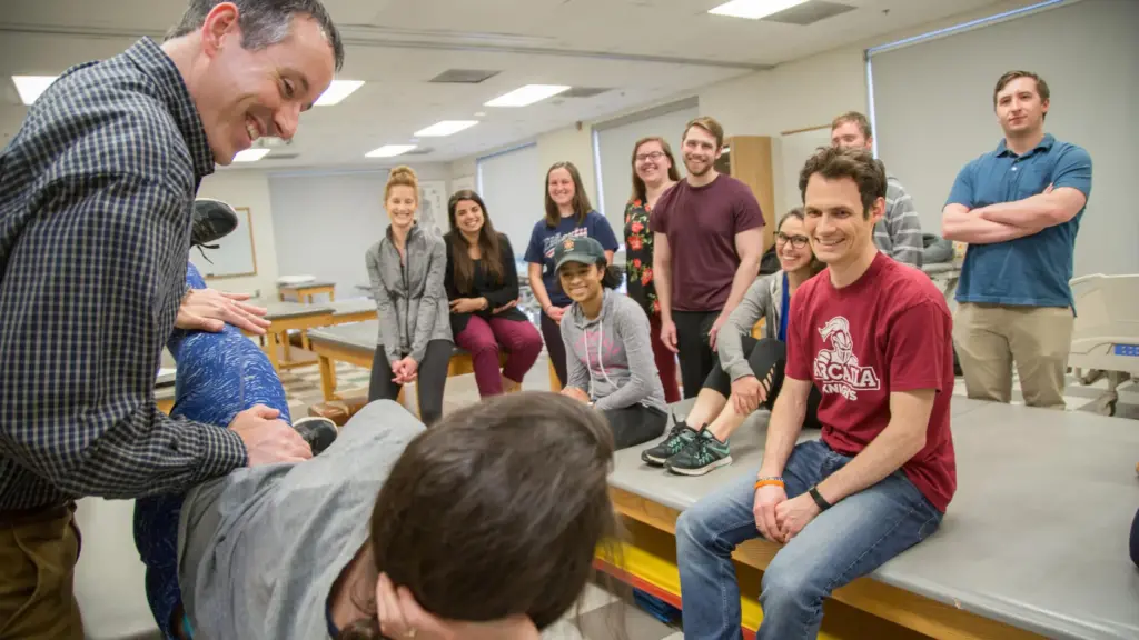 A physical therapy professor demonstrates an examination on a student.