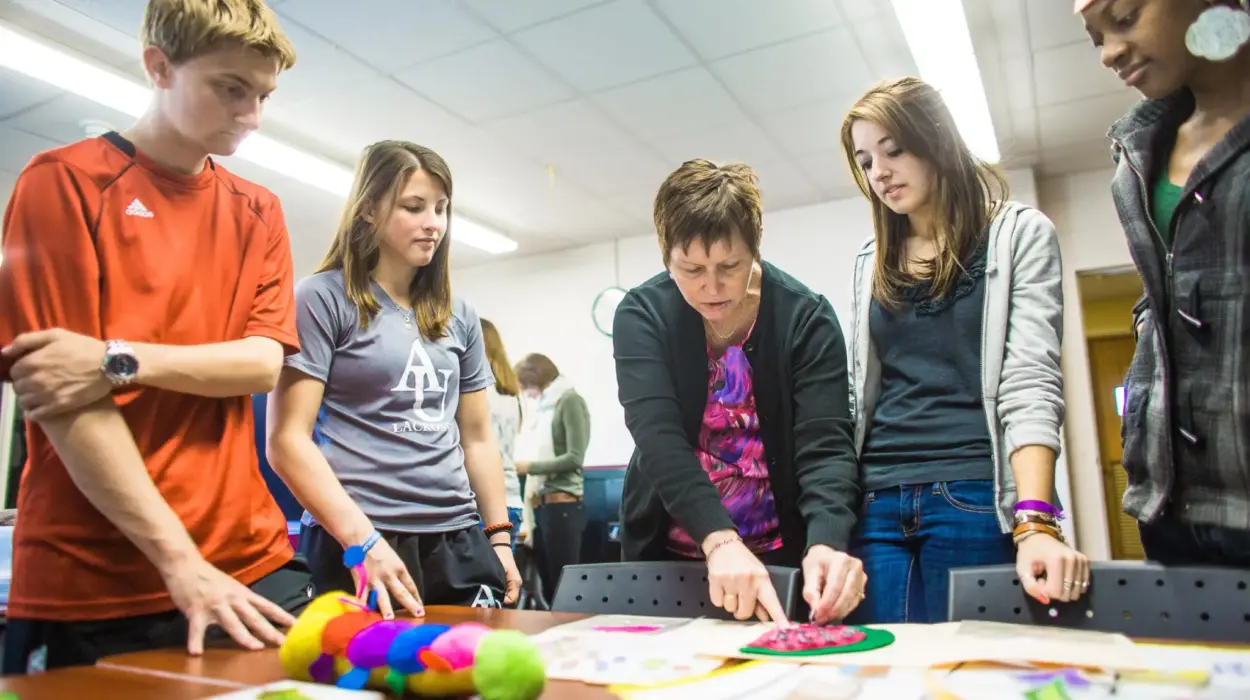 A professor shows students classroom resources for children.