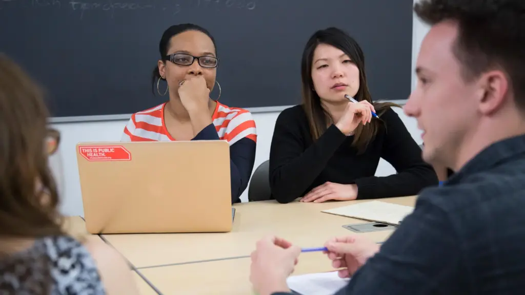 Public Health major students have a discussion while sitting around a table.