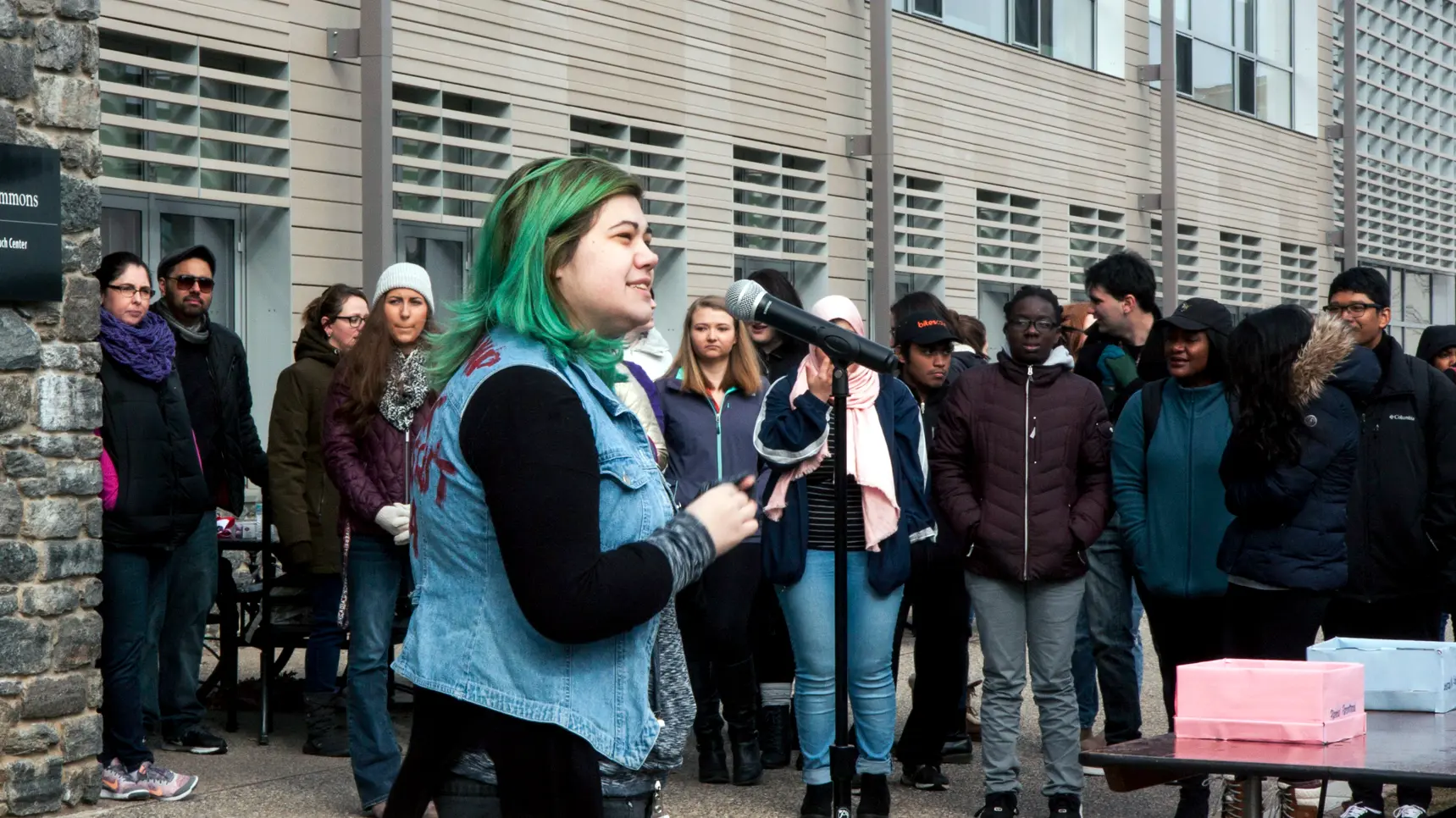 A student at a rally speaking in front of a group of other students
