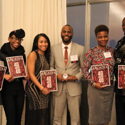 Six people stand close together and smile, holding copies of Arcadia Magazine with the words "40 Under 40" on the cover