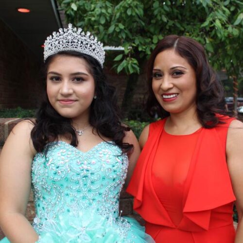 Mother and daughter dressed up in fancy clothes.