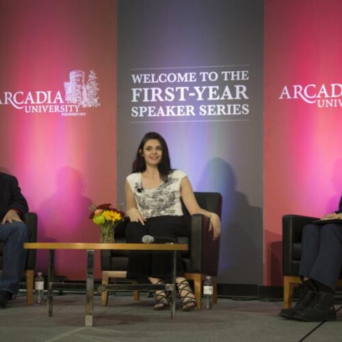 Nicoles Maines with two other people on stage discussing LGBTQ+ activism during the First-Year Speaker Series