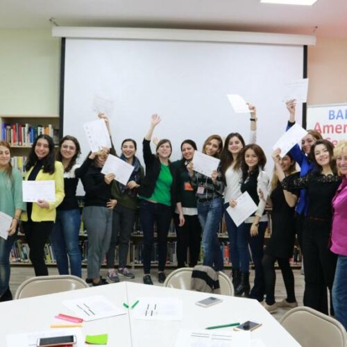 Line up of women smiling with papers.