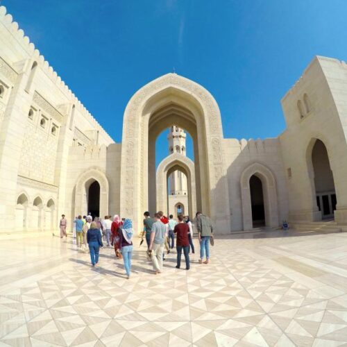 Photo of students studying abroad walking through white marble and stone buildings.