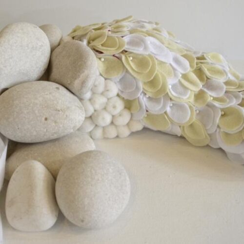 A work of art made of white stones and white and cream colored petals
