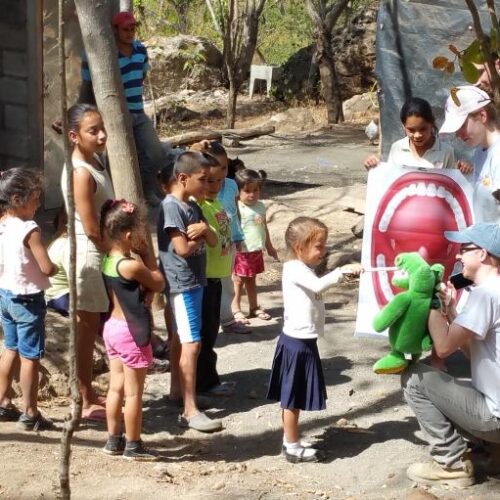 Three people teaching children about good dental care.