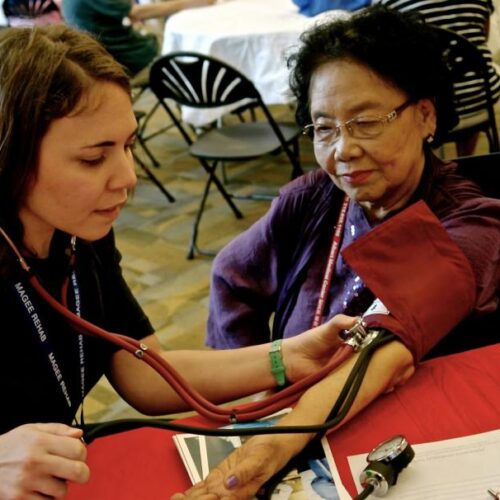 Student measuring patient's blood pressure.