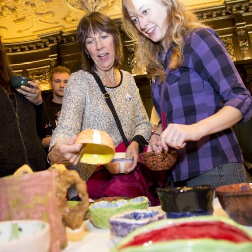 Visitors peruse various hand-crafted bowls at the Empty Bowl global hunger awareness event