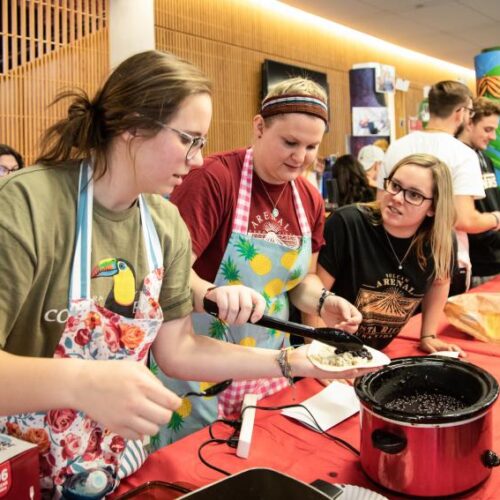 Three students preparing international food in the Commons.