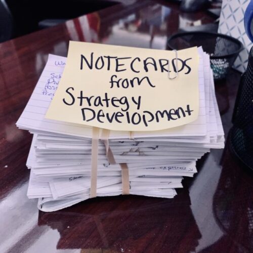 Stack of notecards, the top one reads "Notecards from strategy development"