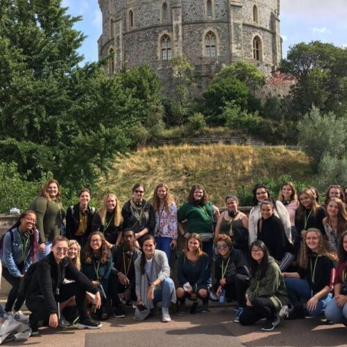 First-year students posed in front of greenery and castle pillar.