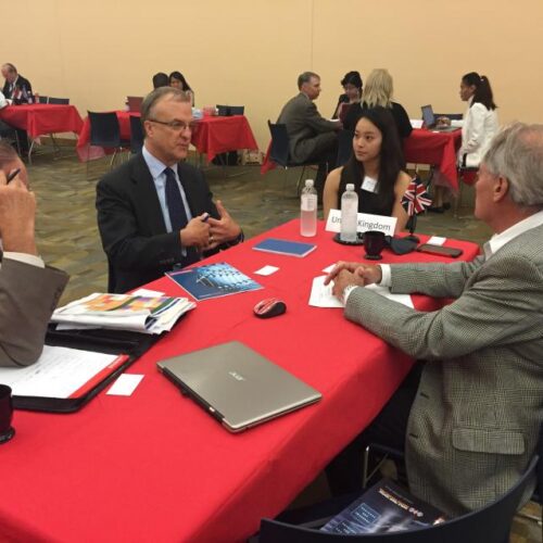 Representatives of the United Kingdom have a discussion at a red table