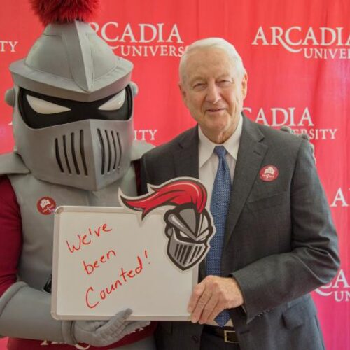 Arcadia Knight and senior leadership member hold a sign that reads "We've been counted!"