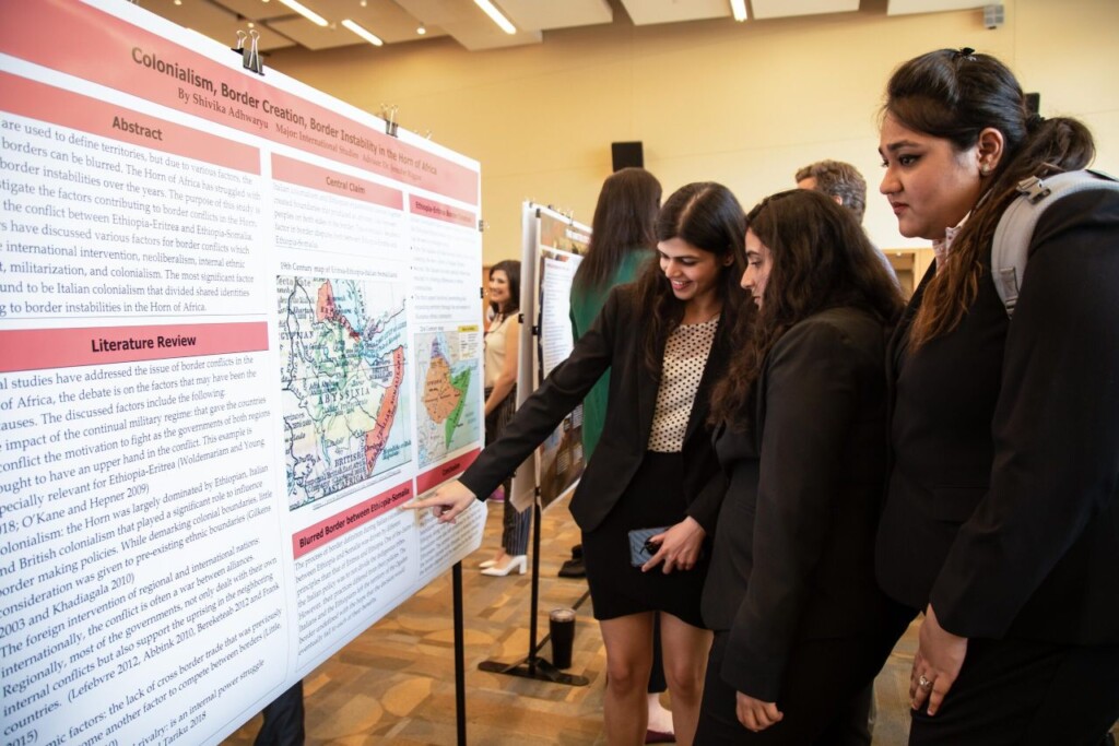 Students look at a presentation board and map during a campus Capstone event.