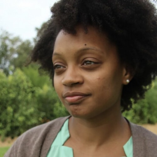 A headshot of Arcadia MFA alum Rebekah Coxwell thoughtfully looking into the distance.