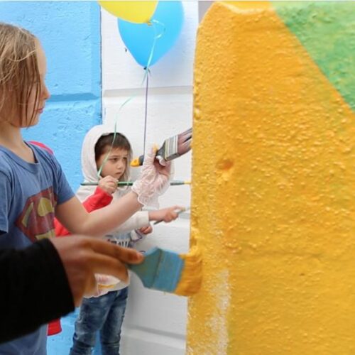 Children helping to paint a mural in Glenside