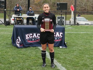 Women's Soccer player holding an ECAC trophy