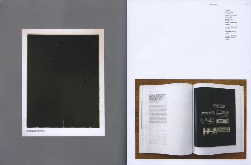 A black screen with a white border and a photo of an open book with a black sheet with symbols on it