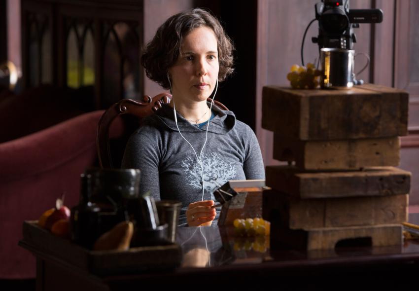 Abbey Ryan wearing headphones while recording a painting demonstration.