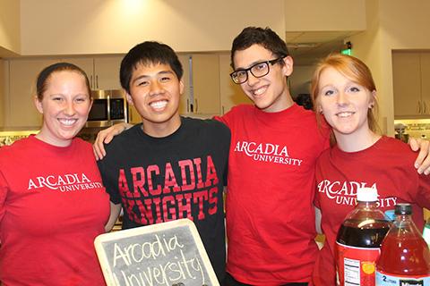 A group of four Arcadia students smile in a kitchen
