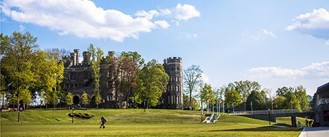 A person walking on Haber Green with Grey Towers Castle in the background