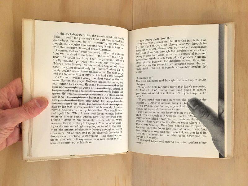 An open book with one real hand on the left side and a photo of a hand on the page on the right side