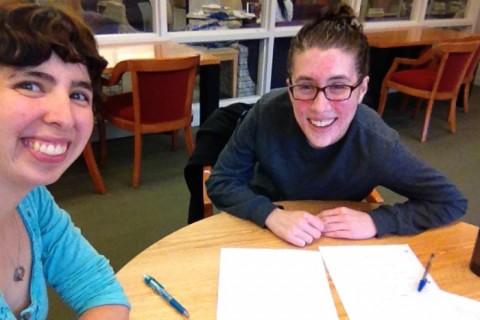 Two students smiling while studying.