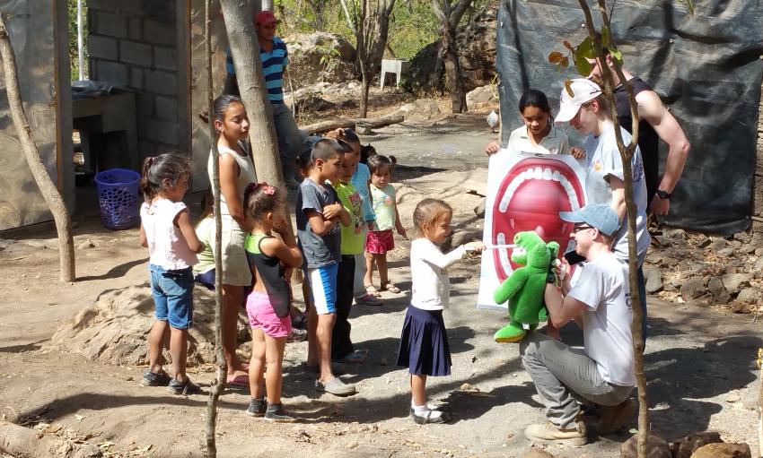 Three people teaching children about good dental care.